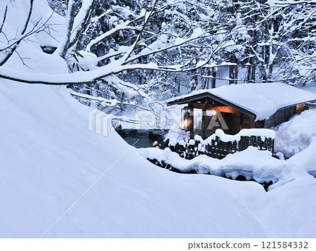 An open-air bath surrounded by snowy scenery in winter 121584332