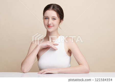 Beautiful young woman with clean fresh skin on beige background, Face care, Facial treatment, Cosmetology, beauty and spa, women portrait. Beautiful young woman with clean fresh skin on beige background, Face care, Facial treatment, Cosmetology, beauty and spa, women portrait. 121584354
