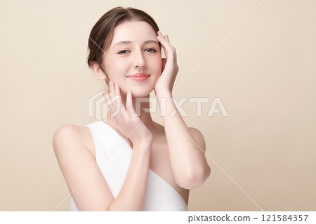 Beautiful young woman with clean fresh skin on beige background, Face care, Facial treatment, Cosmetology, beauty and spa, women portrait. Beautiful young woman with clean fresh skin on beige background, Face care, Facial treatment, Cosmetology, beauty and spa, women portrait. 121584357