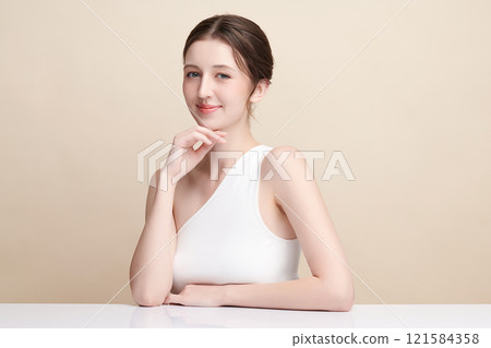 Beautiful young woman with clean fresh skin on beige background, Face care, Facial treatment, Cosmetology, beauty and spa, women portrait. Beautiful young woman with clean fresh skin on beige background, Face care, Facial treatment, Cosmetology, beauty and spa, women portrait. 121584358
