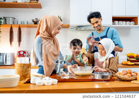 Asian muslim father, mother and brother cheer up the girl to mix flour in the bowl and stay together in kitchen of their house. Asian muslim father, mother and brother cheer up the girl to mix flour in the bowl and stay together in kitchen of their house. 121584637