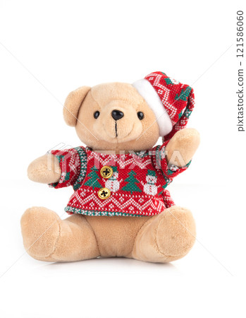 Plush teddy bear wearing a festive red Christmas sweater and hat, isolated on white background Plush teddy bear wearing a festive red Christmas sweater and hat, isolated on white background 121586060