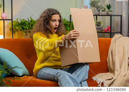 Happy child girl shopper unpacking cardboard box delivery parcel online shopping purchase at home Happy child girl shopper unpacking cardboard box delivery parcel online shopping purchase at home 121586086