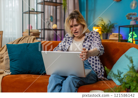 Sad woman using laptop notebook typing browsing working loses bad news game fail computer virus 121586142