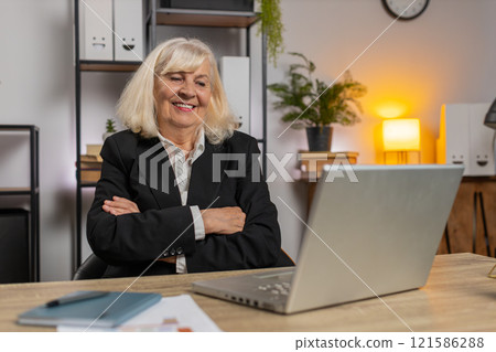 Smiling senior businesswoman grandma closing laptop after finishing work at home office desk Smiling senior businesswoman grandma closing laptop after finishing work at home office desk 121586288