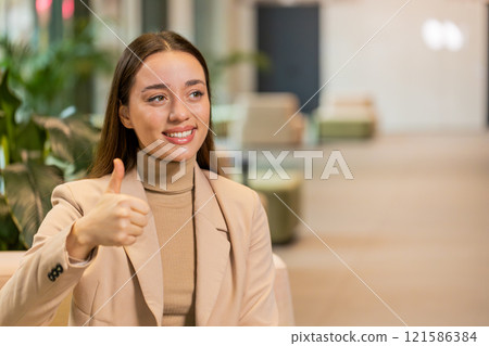 Portrait of smiling Caucasian young businesswoman girl in formal showing thumb up in hotel lobby Portrait of smiling Caucasian young businesswoman girl in formal showing thumb up in hotel lobby 121586384