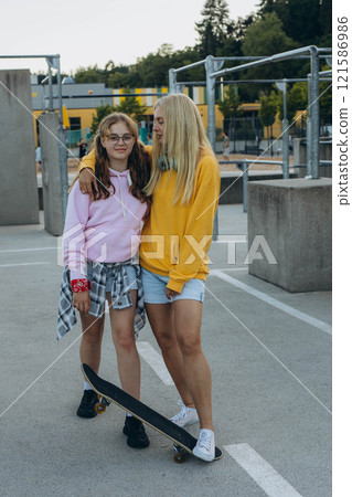 young mother with her daughter riding a skateboard in the park. mother with teenager 121586986