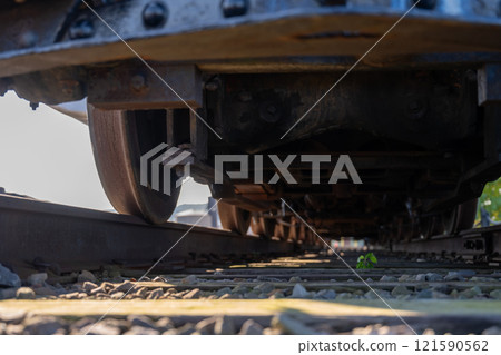 Track level view of a railroad train and wheels as they cross over 121590562