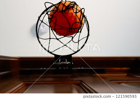 Selective focus on the netting of a miniature toy basketball hoop on the door of a bedroom.  121590593