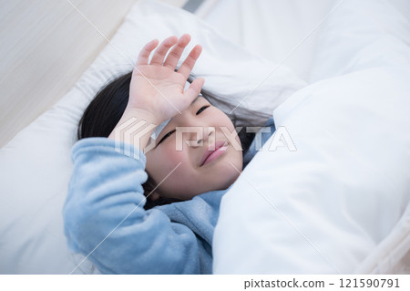 Child with fever cools head, catches cold and stays in bed with headache 121590791