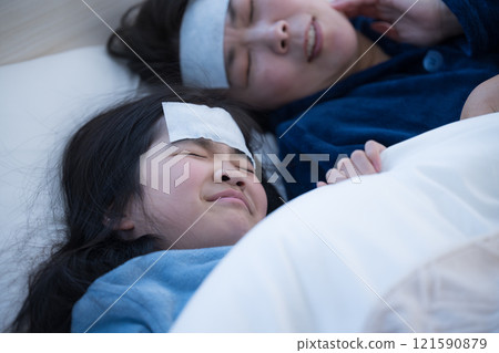 一位母親得了孩子的感冒並發燒——這是一種家庭流行病 一位母親得了孩子的感冒並發燒——這是一種家庭流行病 121590879