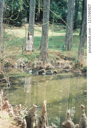 一個女人全身都站在森林裡的湖上 121590907