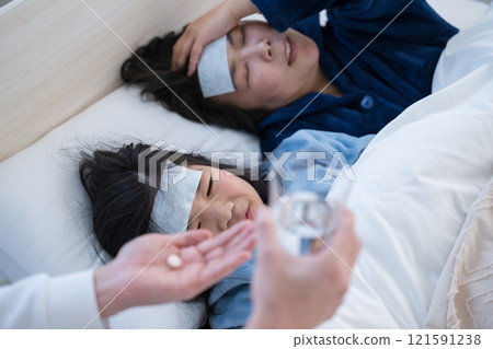 A parent and child who have caught a cold at home and the medicine 121591238