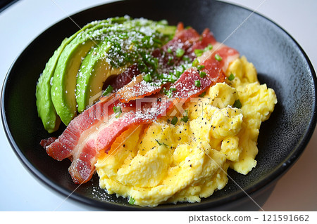 This overhead shot features a keto breakfast with scrambled eggs, bacon and avocado presented  121591662