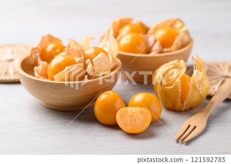 Cape gooseberry or Golden berry (Physalis peruviana) in wooden bowl on white background 121592785