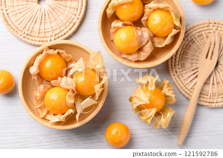 Cape gooseberry or Golden berry (Physalis peruviana) in wooden bowl on white background 121592786