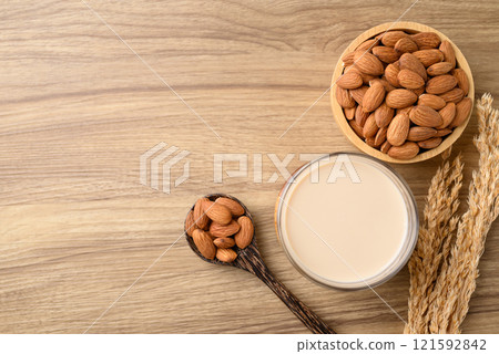 Almond milk in cup glass on wooden table, Alternative milk made from plant, non dairy Almond milk in cup glass on wooden table, Alternative milk made from plant, non dairy 121592842