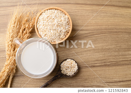 Oat milk in cup glass on wooden table, Alternative milk made from plant, non dairy Oat milk in cup glass on wooden table, Alternative milk made from plant, non dairy 121592843
