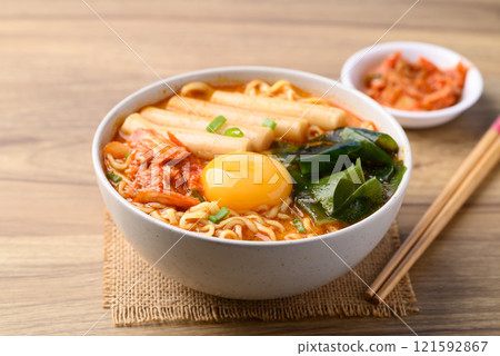 Spicy noodles soup with Tteokbokki, Wakame seaweed and fresh egg yok eating with kimchi cabbage 121592867