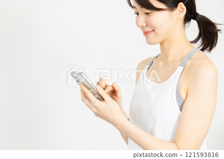 穿著運動服的女人操作智慧型手機 02 121593816