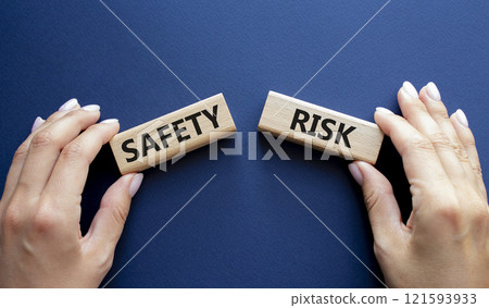 Safety or Risk symbol. Concept word Safety or Risk on wooden blocks. Businessman hand. Beautiful deep blue background. Business and Safety or Risk concept. Copy space Safety or Risk symbol. Concept word Safety or Risk on wooden blocks. Businessman hand. Beautiful deep blue background. Business and Safety or Risk concept. Copy space 121593933