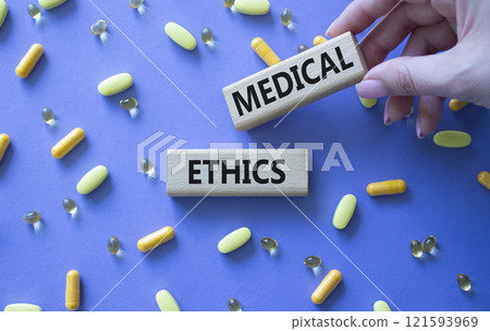 Medical Ethics symbol. Concept word Medical Ethics on wooden blocks. Doctor Hand. Beautiful purple background with pills. Medicine and Medical Ethics concept. Copy space Medical Ethics symbol. Concept word Medical Ethics on wooden blocks. Doctor Hand. Beautiful purple background with pills. Medicine and Medical Ethics concept. Copy space 121593969