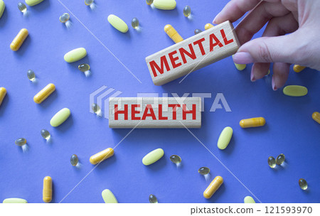 Mental Health symbol. Concept word Mental Health on wooden blocks. Doctor Hand. Beautiful purple background with pills. Medicine and Mental Health concept. Copy space Mental Health symbol. Concept word Mental Health on wooden blocks. Doctor Hand. Beautiful purple background with pills. Medicine and Mental Health concept. Copy space 121593970