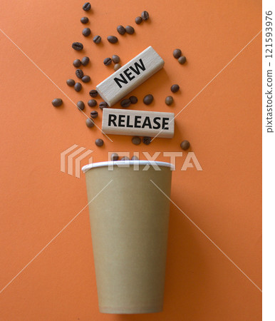 New Release symbol. Concept word New Release on wooden blocks. Beautiful orange background with coffee cup. Business and New Release concept. Copy space 121593976