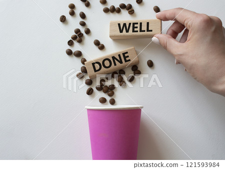 Well done symbol. Concept word Well done on wooden blocks. Businessman hand. Beautiful white background with coffee cup. Business and Well done concept. Copy space Well done symbol. Concept word Well done on wooden blocks. Businessman hand. Beautiful white background with coffee cup. Business and Well done concept. Copy space 121593984