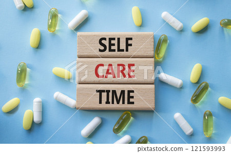 Self-care Time symbol. Concept words Self-care Time on wooden blocks. Beautiful blue background with pills. Healthcare and Self-care Time concept. Copy space. 121593993