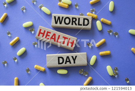 World Health Day symbol. Concept words World Health Day on wooden blocks. Beautiful purple background with pills. Healthcare and World Health Day concept. Copy space. 121594013