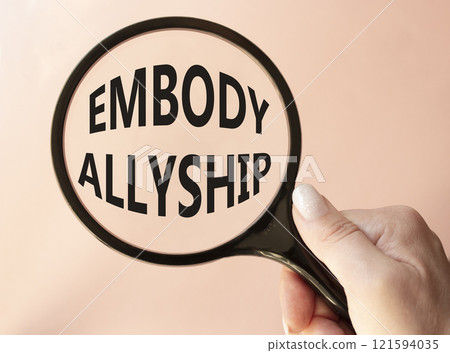 Embody Allyship symbol. Concept word Embody Allyship on magnifying glass. Beautiful pink background. Businessman hand. Business and Embody Allyship concept. Copy space 121594035