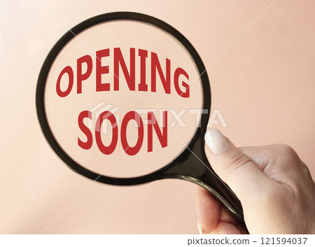 Opening soon symbol. Magnifying Glass with Concept word Opening soon. Beautiful pink background. Businessman hand. Business and Opening soon concept. Copy space Opening soon symbol. Magnifying Glass with Concept word Opening soon. Beautiful pink background. Businessman hand. Business and Opening soon concept. Copy space 121594037