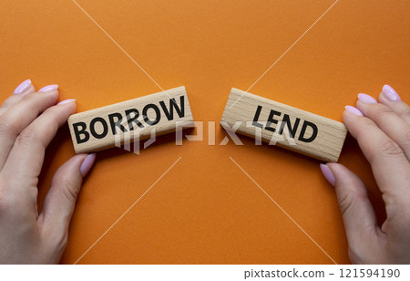 Lend or Borrow symbol. Concept word Lend or Borrow on wooden blocks. Businessman hand. Beautiful orange background. Business and Lend or Borrow concept. Copy space Lend or Borrow symbol. Concept word Lend or Borrow on wooden blocks. Businessman hand. Beautiful orange background. Business and Lend or Borrow concept. Copy space 121594190