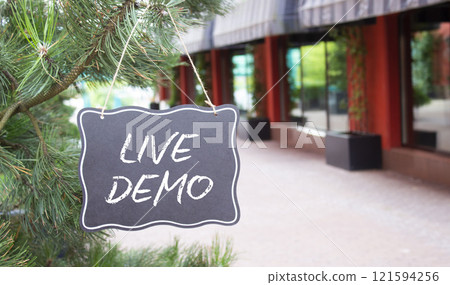 Live Demo symbol. Concept words Live Demo on black chalk background. Beautiful background with shop and plants. Business and Live Demo concept. Copy space. Live Demo symbol. Concept words Live Demo on black chalk background. Beautiful background with shop and plants. Business and Live Demo concept. Copy space. 121594256