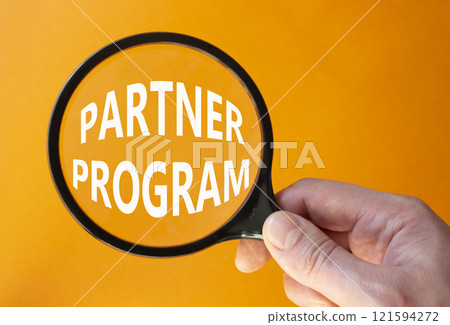 Partner Program symbol. Concept words Partner Program on magnifying glass. Businessman hand. Beautiful orange background. Business and Partner Program concept. Copy space. Partner Program symbol. Concept words Partner Program on magnifying glass. Businessman hand. Beautiful orange background. Business and Partner Program concept. Copy space. 121594272