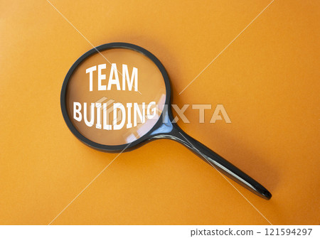 Team Building symbol. Concept word Team Building on magnifying glass. Beautiful orange background. Business and Team Building concept. Copy space 121594297