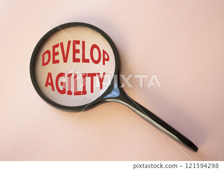 Develop agility symbol. Concept word Develop agility on magnifying glass. Beautiful pink background. Business and Develop agility concept. Copy space 121594298