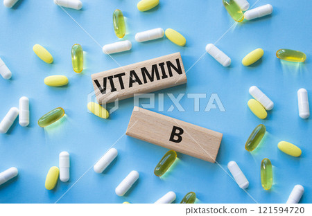 Vitamin B symbol. Concept word Vitamin B on wooden blocks. Beautiful blue background with pills. Medicine and Vitamin B concept. Copy space Vitamin B symbol. Concept word Vitamin B on wooden blocks. Beautiful blue background with pills. Medicine and Vitamin B concept. Copy space 121594720