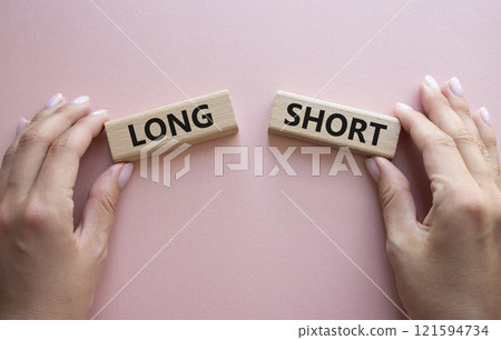 Short vs Long symbol. Concept word Short vs Long on wooden blocks. Businessman hand. Beautiful pink background. Business and Short vs Long concept. Copy space 121594734