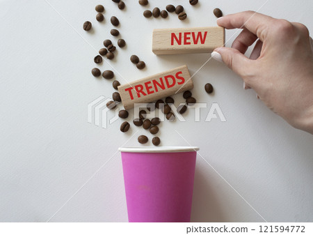 New Trends symbol. Concept word New Trends on wooden blocks. Businessman hand. Beautiful white background with coffee cup. Business and New Trends concept. Copy space 121594772