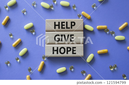 Help Give Hope symbol. Concept word Help Give Hope on wooden blocks. Beautiful purple background with pills. Medicine and Help Give Hope concept. Copy space 121594799