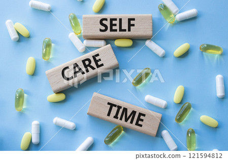 Self-care Time symbol. Concept words Self-care Time on wooden blocks. Beautiful blue background with pills. Healthcare and Self-care Time concept. Copy space. 121594812