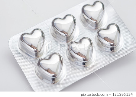 Heart shaped pills blister in foil, love drugs packaging set on white background as a symbol of love, health, and medicine. Perfect for themes of healthcare, romance, and pharmaceutical design. 121595134