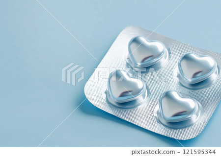 Heart shaped pills blister in foil, love drugs packaging set on blue background as a symbol of love, health, and medicine. Perfect for themes of healthcare, romance, and pharmaceutical design. 121595344