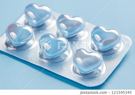 Heart shaped pills blister in foil, love drugs packaging set on blue background as a symbol of love, health, and medicine. Perfect for themes of healthcare, romance, and pharmaceutical design. 121595345