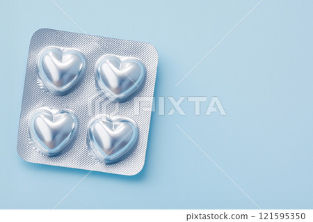 Heart shaped pills blister in foil, love drugs packaging set on blue background as a symbol of love, health, and medicine. Perfect for themes of healthcare, romance, and pharmaceutical design. 121595350