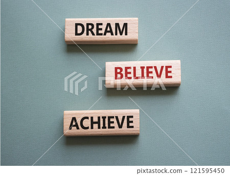 Dream Believe Achieve symbol. Wooden blocks with words Dream Believe Achieve. Beautiful grey green background. Business and Dream Believe Achieve concept. Copy space. 121595450