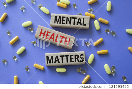 Mental Health Matters symbol. Concept words Mental Health Matters on wooden blocks. Beautiful purple background with pills. Healthcare and Mental Health Matters concept. Copy space. 121595455