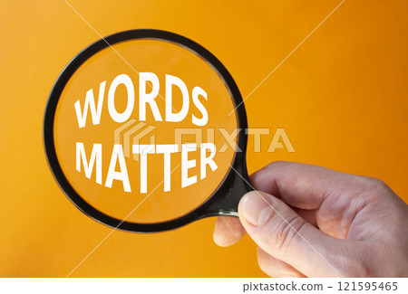 Words Matter symbol. Magnifying Glass with Concept word Words Matter. Businessman hand. Beautiful orange background. Business and Words Matter concept. Copy space 121595465